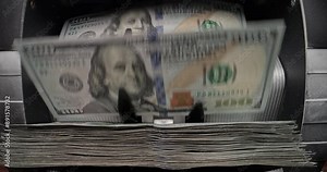 Money counting machine quickly, reliably, accurately counts large sums of American dollars. Banknote counter counts dollars. Cash is stacked in neat piles. Profit and financial investment, copy space.