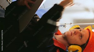 Vertical video: Industrial engineer in helmet inspects turbine pre-engine start. Industrial engineer's expertise in turbine examination showcased. Industrial engineer ensures operational safety.