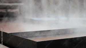 An evaporation tank, used in the maple tree sugaring process to obtain syrup from the raw material (sap) by boiling it. Rack focus handheld shot.