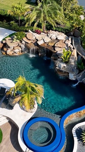 Check out this incredible Insane Pool completed in Central Florida. This backyard features a massive grotto, infinity edge, spa, sun shelf, and a water slide. #insanepools #lucaslagoons #waterslide #backyardgoals | Lucas Lagoons