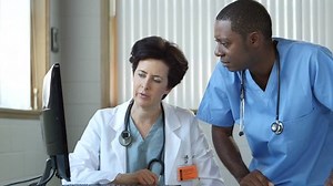 2 Doctors looking at computer and consulting in a medical office