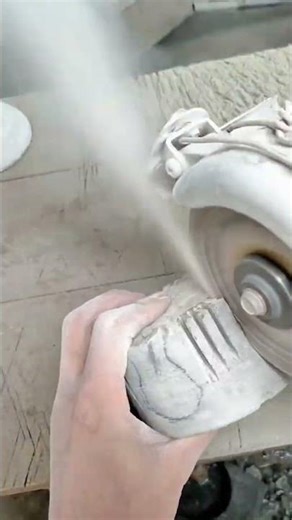 Cutting stone surface with grinder, creating shape with steady hand control