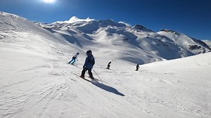 Kids learning how to ski with the ski instructor in the mountains