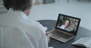 Mature old woman speaking with son and explaining by video call looking at laptop. Distance language learning with student and tutor online education concept. Stay home remote work at old age.