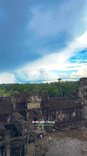 This is the view surrounding Angkor Wat Temple. It was taken from the highest tower, the most sacred place of Angkor Wat, called Bakan. The view is truly beautiful. You can also see the long causeway bridge with many tourists walking across it. | Walk With Chang