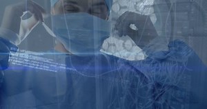 Male surgeon putting on a surgical mask in a hospital operating theatre the video is set against a black background and the surgeon is wearing a surgical cap and gown.