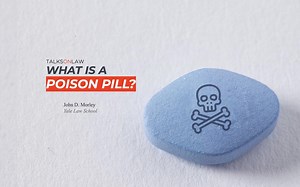 What is a poison pill and how is it used to stop a hostile acquisition?