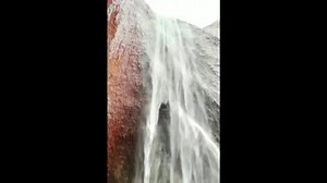 Water cascades down Australia's Uluru