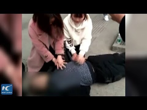 Women perform CPR in the street