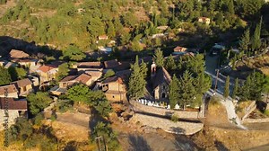 Aerial drone footage of traditional deserted medieval countryside village Phicardou (Fikardou), Nicosia, Cyprus. Reveal scene of old abandoned ceramic tiled roof houses and church from above.