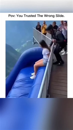 Silicon Web🆇 | This instagram post shares a 29-second Al-generated video from InVideo, showing crowds sliding down a massive blue inflatable over a foggy... | Instagram