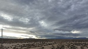 Dark storm clouds over the Mojave Desert's arid landscape hoping for rain - aerial flyover