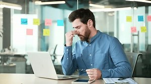 clip-3434709085-overworked-bearded-businessman-suffering-eye-strain ...