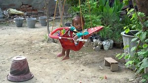 Kid, child swinging on a swing on a tree, Noida, 21 June 2021 India