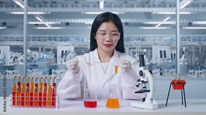 Asian Woman Scientist Making Experiment With Test Tube On The Table With Microscope In The Laboratory. Carrying Out Experiments, Working In The Lab Analyzing Her Finding Samples Test Tube