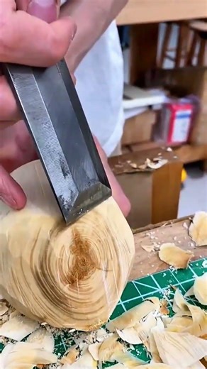 shaping a wooden block using a sharp chisel to create a smooth surface for a woodworking project
