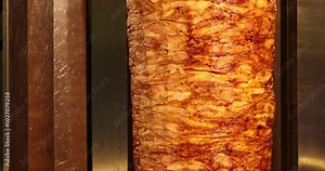 rotating spit with meat sizzling on fire in open kitchen of Asian street cafe. Stock Video