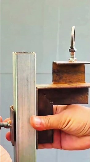 Hands hold welded steel frame with ring bolt