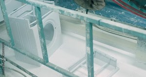 Production of household appliances, conveyor, degreasing and coating with a white layer of washing machine bodys, aluminum bodies transported on the production line.