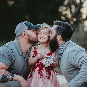 Dad and step-dad pose with daughter before father-daughter dance