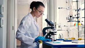 Lab worker pouring the solution on the glass.