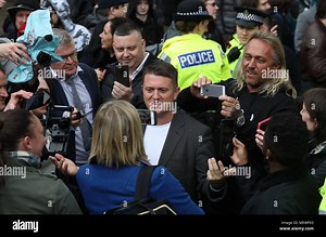 Former English Defence League leader Tommy Robinson (centre) outside Airdrie Sheriff Court after Mark Meechan was fined £800 for an offence under the Communications Act for posting a YouTube video of a dog giving Nazi salutes Stock Photo - Alamy