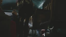 MEDIUM ANGLE OF LEGS OF PEOPLE SITTING ON BUS. PEOPLE GET UP AND EXIT...