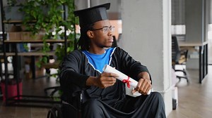 Thoughtful African American graduate in wheelchair holding diploma