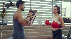 Beautiful young asian woman training boxing at finess class. Male coach giving a Private training to a female athlete practicing a punch. Stock Video