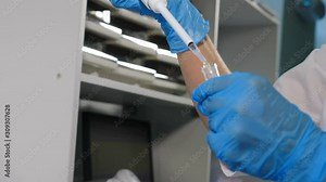 Close up of pipette with liquid dropping intro glass test tube in laboratory. Working with Test Tubes. Specialist in Innovative Pharmaceutical Laboratory with Modern Medical Equipment for Genetics