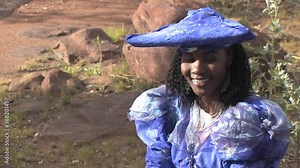 herero woman wearing a Victorian style dress outdoors in a village in north Botswana