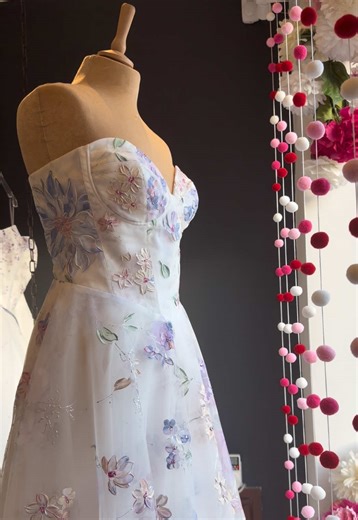 VALENTINES DAY IS COMING ♥️ Time to fall in love with Bloom, looking sensational in our boutique window today. Handpainted flowers 🌺 Yes please 🙏 #colouredweddingdress #colourfulweddingdress #floralweddingdress #2026bride #uniqueweddingdress