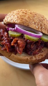 A vegan pulled pork sandwich is easy to make with jackfruit. This bbq jackfruit sandwich recipe is cooked on the stove and then in the oven to give the shredded filling a slightly crisp that tastes amazing when served up on a bun. Recipe: https://plantbasedonabudget.com/bbq-jackfruit-sandwich/ | Plant-Based on a Budget