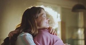 Two women hugging each other