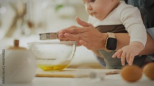 Breakfast. Mom pastry chef using kitchen utensils mom and little child preparing pastries in her home. Caucasian woman preparing pancakes for breakfast uses newest sling for comfort, baby clothes