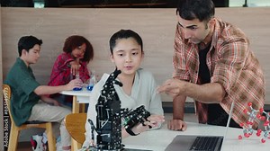 In classroom setting teacher aids student in crafting a robotic arm for design and technology lesson. Encouraging teamwork innovation and coding skills in science education. Robot hand. Innovation