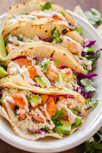 These Shrimp Tacos are loaded with plump, juicy shrimp, crunchy cabbage, cotija cheese, and the best garlic-lime crema shrimp taco sauce that will win you over. (Recipe in Comments) | NatashasKitchen.com