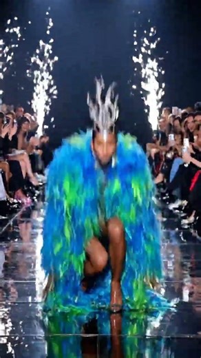 Supermodel in wild designer outfit hilariously trips, recovers with a winning pose.