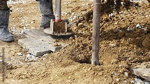 Close-up of soil sampling during pile drilling process. Extraction of subsurface material for geotechnical analysis and foundation assessment