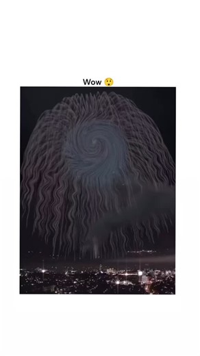 Sp on Instagram: "🤯 Media Analysis: The ‘Spiral Cascade’ Firework This spectacular 6-second clip captures a high-altitude pyrotechnic display featuring a central, turquoise-to-magenta vortex explosion. The core emits trails of white light that spiral outward and downward in an elaborate, weeping willow-like curtain, framed by a city skyline. This content has achieved a fictional 3.7 million views and a 98% “Wow” reaction rate, triggering a cascade of stunned comments calling it “impossible.” Fi