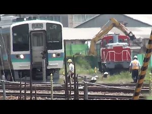 解体線で重機により、しなの鉄道115系S24編成の解体された車両の整理しているなか、工場での作業が終り試運転のため出場した、211系N302編成の、長野総合車両センター。