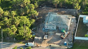 Installation of steel truss frame on unfinished residential house under construction in Florida rural area. Development of american housing concept