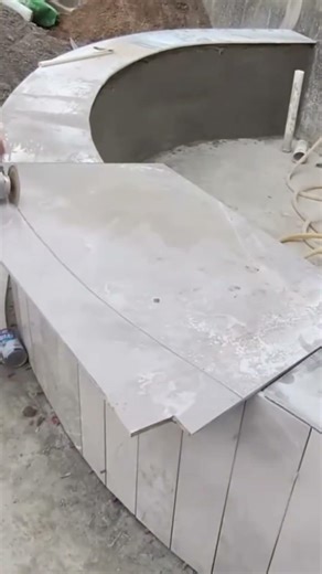 Expert Worker Cutting and Fitting Marble Tiles for Curved Pool Side