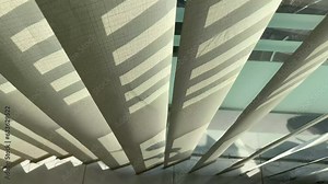 Wind blowing in open window and swaying thin curtain in living room. Ray of sun lighting through transparent curtain on window at evening summer time