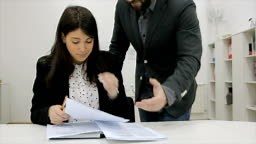 An angry manager strikes his hand on the table,shouting on him...