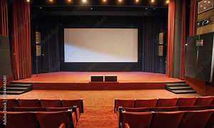 A classic cinema interior with red seating and a blank screen for movie presentations.
