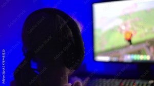 Girl Playing Video Game PC in Headset. Girl Plays Computer Video Game in Room, Cybersport Gaming, Children Gaming Addiction. Child Play Computer Game at Home. Online Video Game Technology.
