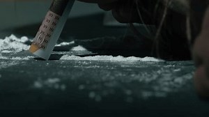 Drug addict snorting line of cocaine close up slow motion zoom show selective focus