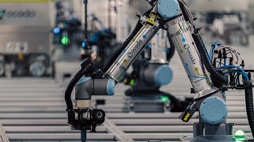 Ocado robots work with robotic arms