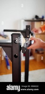 securely positioning bracket onto vertical steel, precise hand placement for mounting steel support bracket, carefully aligning and securing mounting bracket on indoor workout equipment post Stock Video Footage - Alamy